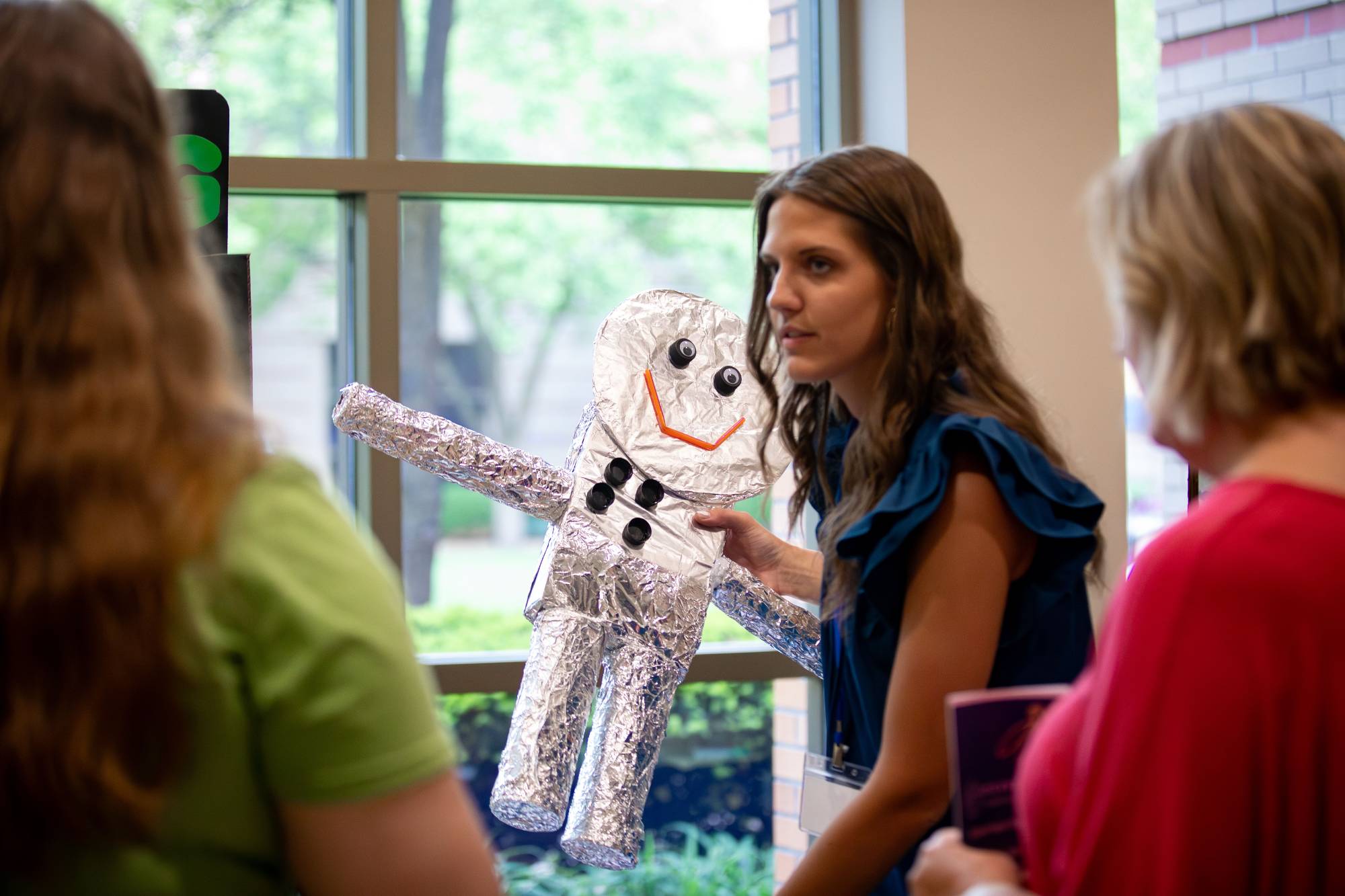 An educator standing in front of their table at the Groundswell Student Project Showcase